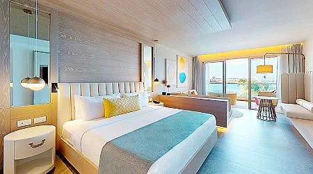 Habitaci&oacute;n de hotel luminosa con cama doble y vista al exterior.