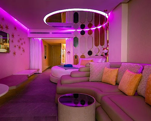 Sala moderna con luces moradas y sof&aacute;, y mesa circular iluminada