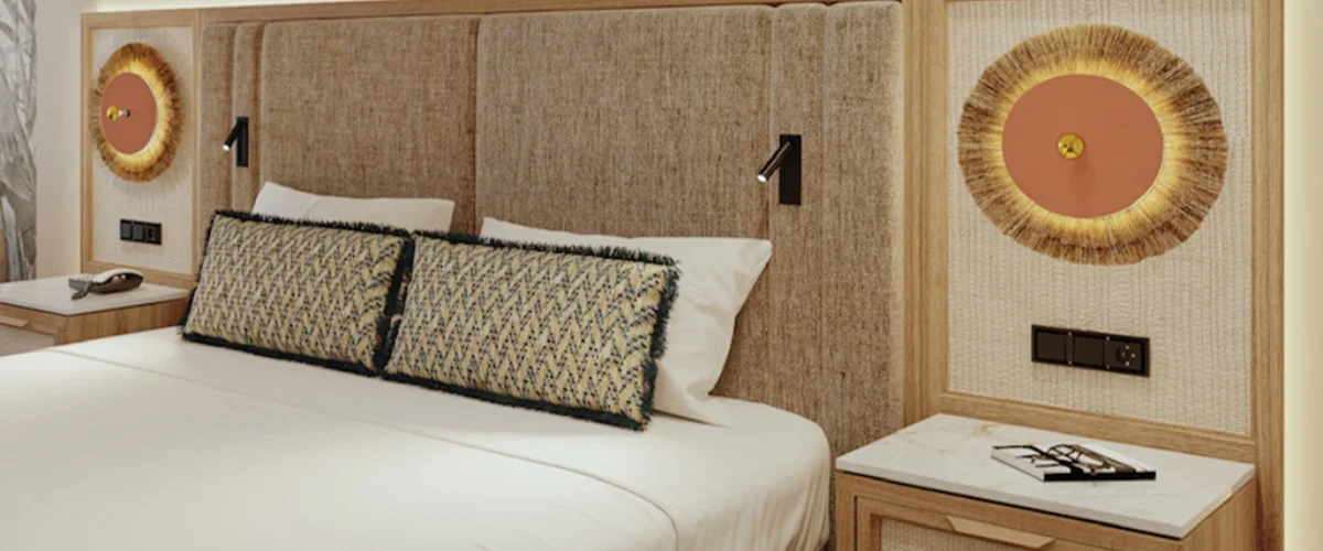 Dormitorio moderno con cama, mesilla y l&aacute;mparas decorativas en la pared