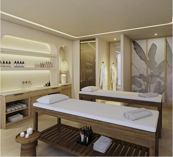 Sala de spa con camas, toallas, botellas y decoraci&oacute;n elegante beige.