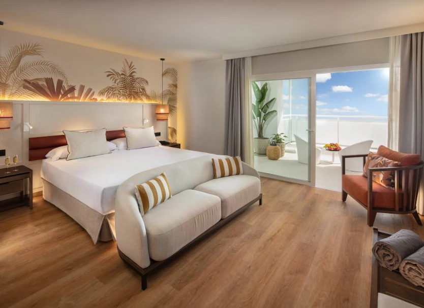 Dormitorio moderno con cama doble, balc&oacute;n y sala junto a la ventana