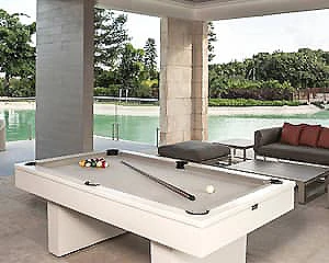 Mesa de billar en terraza con sillones y vista al jard&iacute;n.