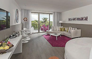 Sala moderna con mesa de comedor, sillones y ventanas con vista al jard&iacute;n