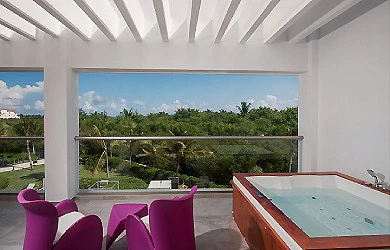 Terraza con piscina al aire libre y sillas p&uacute;rpura bajo techo blanco