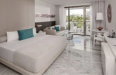 Habitaci&oacute;n de hotel moderna con cama doble y vista al balc&oacute;n.