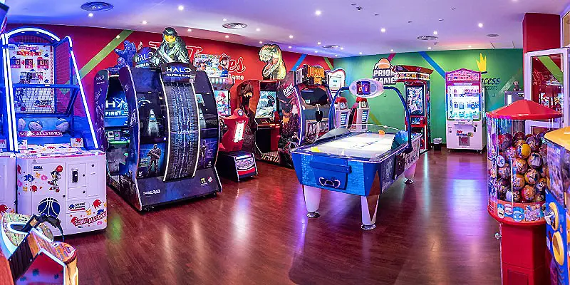 Sala de recreativos con m&aacute;quinas arcade, pinball y mesa de f&uacute;tbol de mesa.