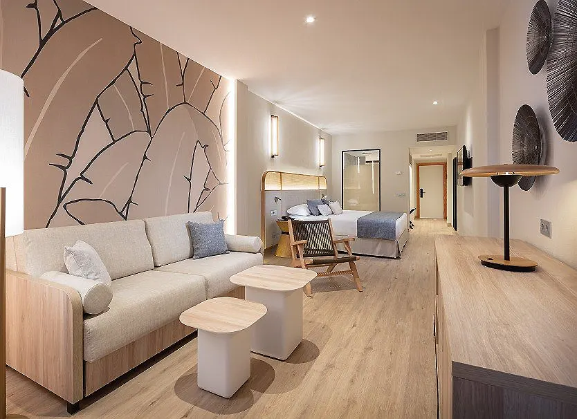 Sala de estar moderna con sof&aacute;, mesas y paredes con arte mural.