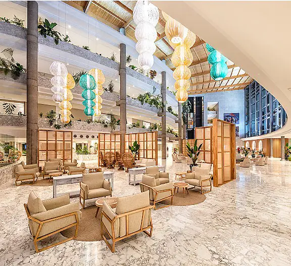 Sal&oacute;n interior con sof&aacute;s, biombos de madera y l&aacute;mparas colgantes decorativas.