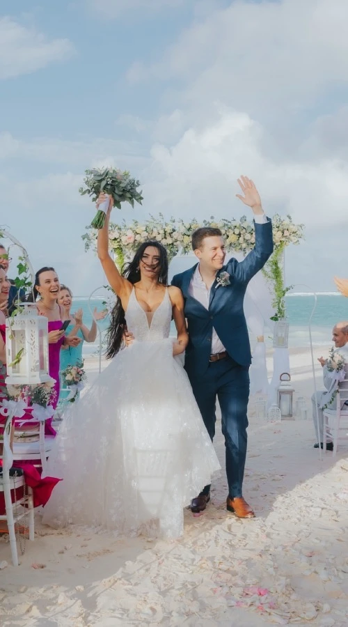 Pareja de novios celebra en boda al aire libre, junto a una ceremonia.
