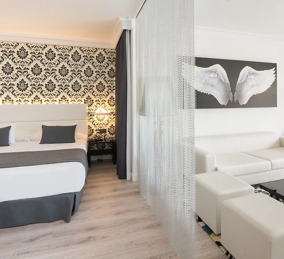 Interior moderno con sof&aacute; blanco, cama y cortina transl&uacute;cida blanca