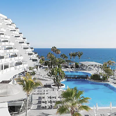 Vistas al mar desde un hotel con piscinas y jardines, costa tropical