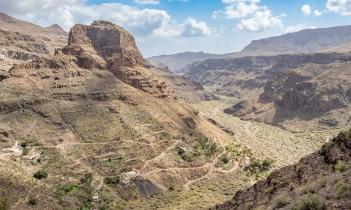 Paisaje de ca&ntilde;ones y monta&ntilde;as &aacute;ridas con senderos y vegetaci&oacute;n dispersa