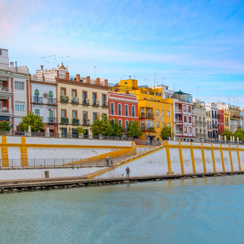 Edificios coloridos junto a un r&iacute;o en un d&iacute;a soleado.
