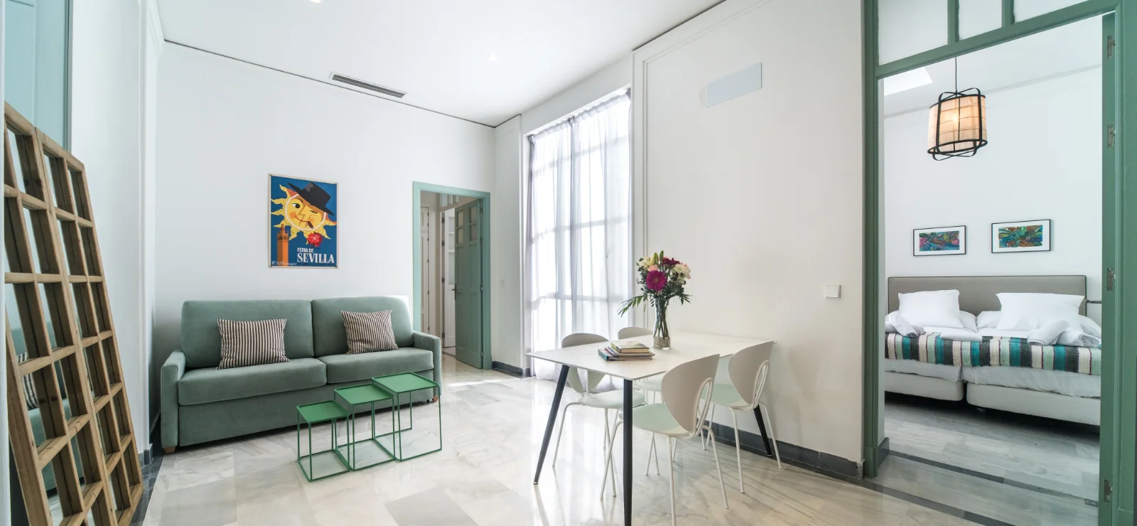 Sala moderna con sof&aacute;, mesa y entrada al dormitorio.