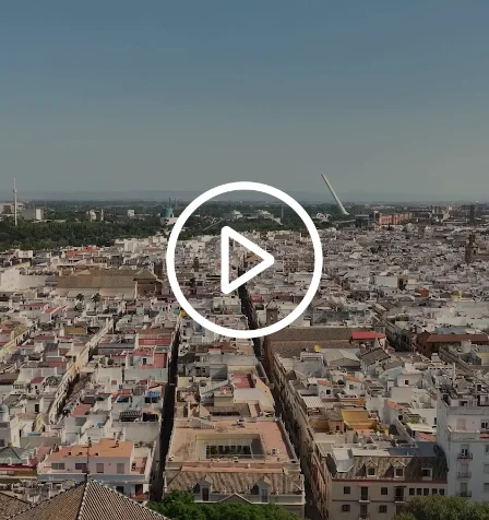 Vista a&eacute;rea de una ciudad con un &iacute;cono de reproducci&oacute;n sobre la imagen.