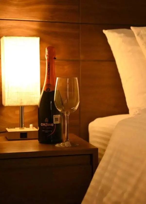 Mesita de noche con botella de cava y copa