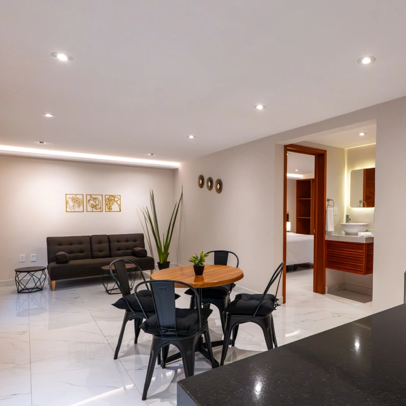 Sala moderna con comedor, sof&aacute; y acceso a ba&ntilde;o y rec&aacute;mara.