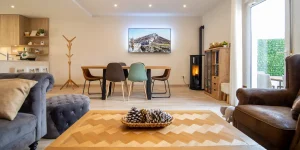 Sala moderna con comedor, sof&aacute;, mesa de centro y chimenea. Decoraci&oacute;n c&aacute;lida y acogedora.