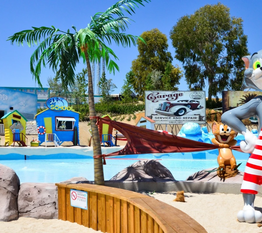 Zona acu&aacute;tica tem&aacute;tica con personajes animados y decoraci&oacute;n tropical.