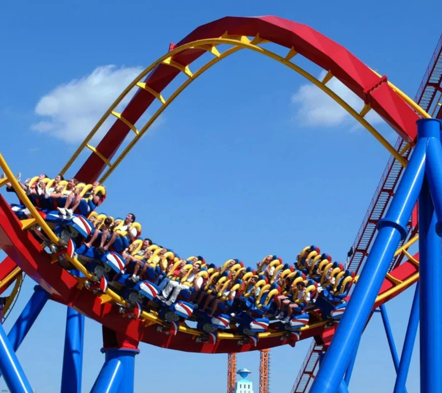 Monta&ntilde;a rusa con personas disfrutando el recorrido bajo un cielo azul.