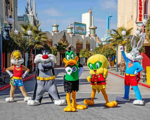 Personajes de dibujos animados disfrazados de superh&eacute;roes en una calle tem&aacute;tica.