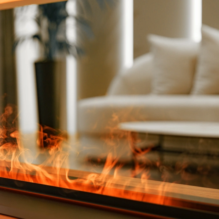 Llama c&aacute;lida frente a un sof&aacute; blanco en una sala moderna.