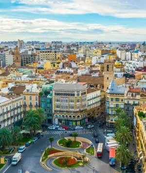 Vista a&eacute;rea de una ciudad con edificios, rotonda y cielo parcialmente nublado.