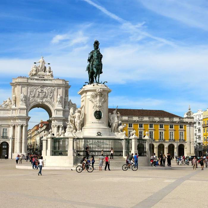 Pra&ccedil;a movimentada com arco e est&aacute;tua equestre em ambiente urbano.