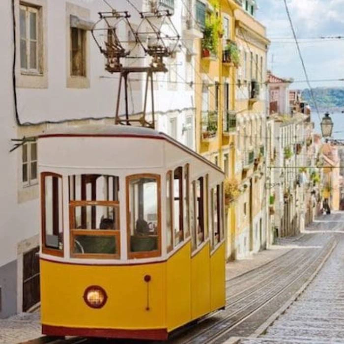 Bonde amarelo descendo rua &iacute;ngreme entre pr&eacute;dios hist&oacute;ricos coloridos.