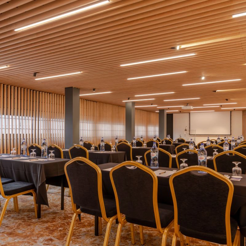 Sala de confer&ecirc;ncias moderna com cadeiras e mesas arrumadas.