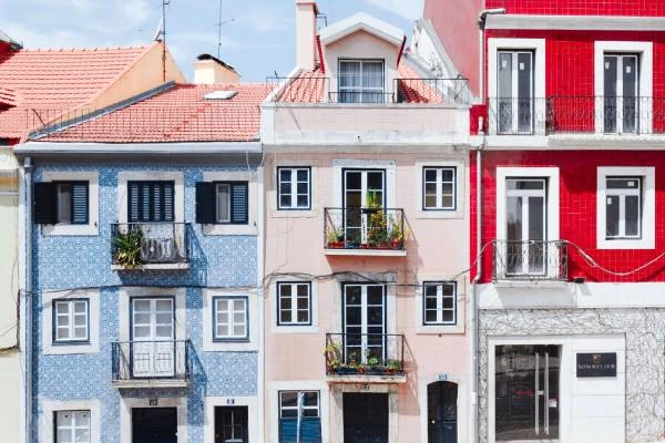 Fachadas coloridas de pr&eacute;dios com varandas e janelas.