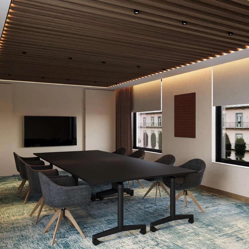 Sala de reuni&atilde;o moderna com mesa preta, poltronas e TV na parede.