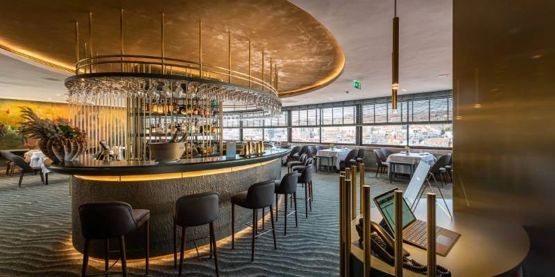 Bar moderno com ilumina&ccedil;&atilde;o elegante e vista panor&acirc;mica da cidade.