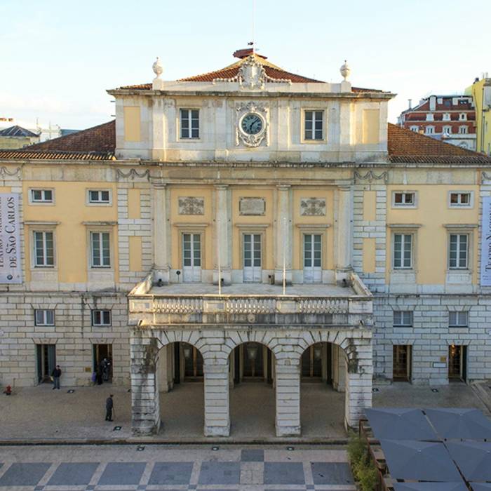 Fachada de um edif&iacute;cio hist&oacute;rico com arco e rel&oacute;gio.