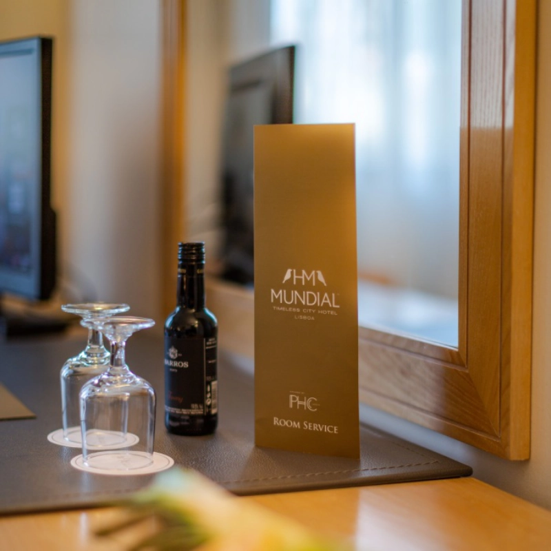 Menu de servi&ccedil;o de quarto com garrafa de vinho e ta&ccedil;as em hotel.