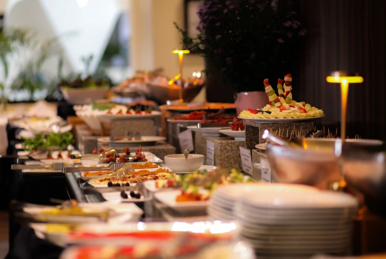 Mesa de buffet con variedad de platos y decoraciones iluminadas.