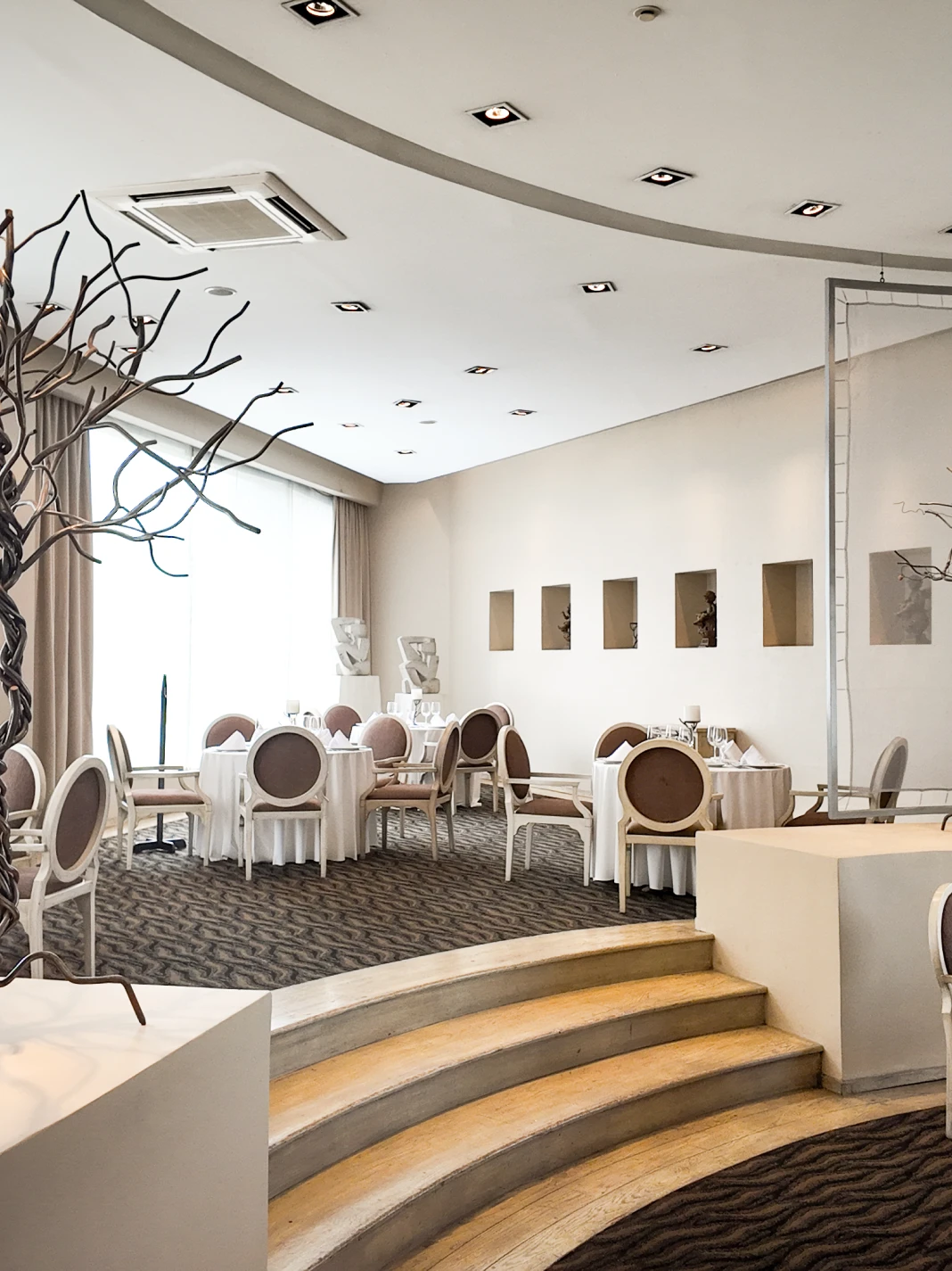 Restaurante elegante con mesas redondas y sillas cl&aacute;sicas.