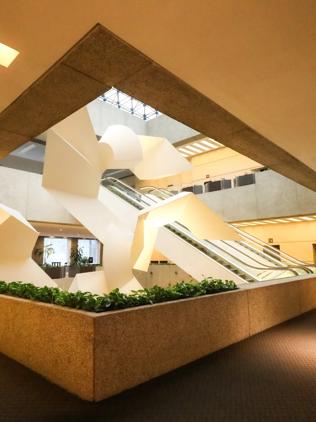 Interior moderno con escaleras y plantas decorativas.