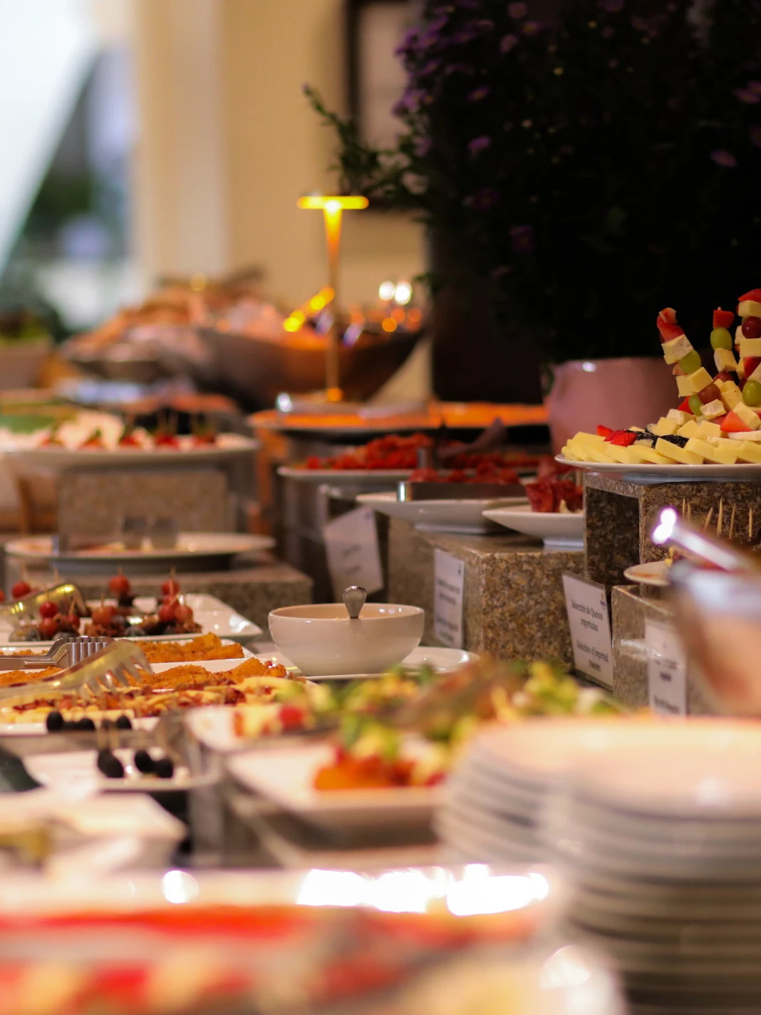 Buffet con platos variados y coloridos en un evento elegante.