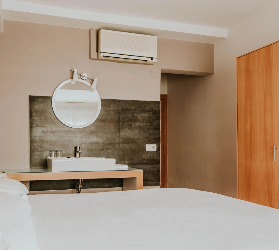 Habitaci&oacute;n moderna con cama grande y ba&ntilde;o peque&ntilde;o integrado.