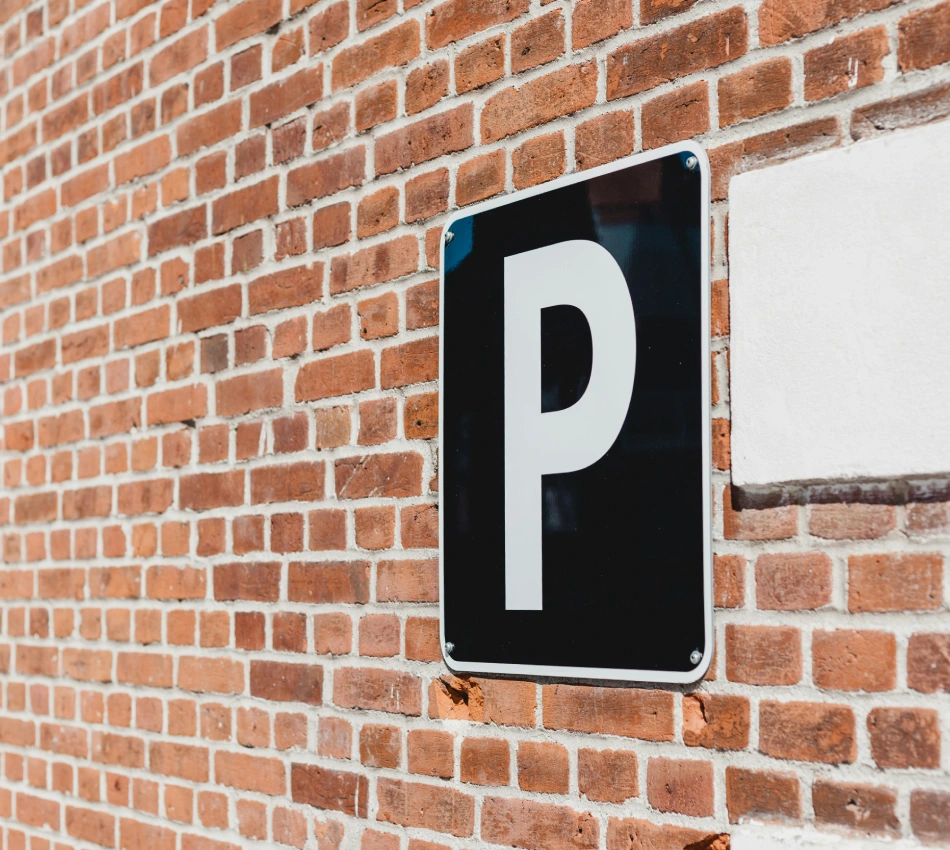 Se&ntilde;al de estacionamiento en una pared de ladrillo.