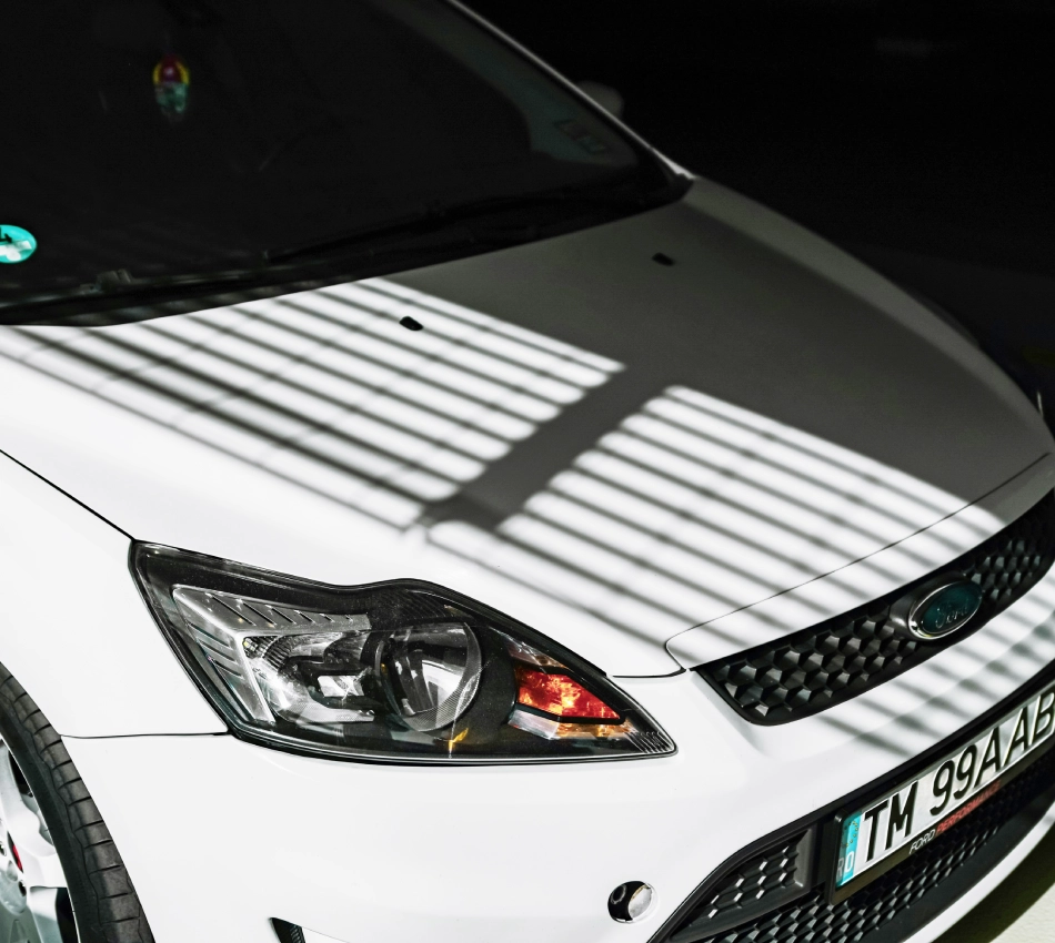 Auto blanco con sombras de rejas en el cap&oacute;.