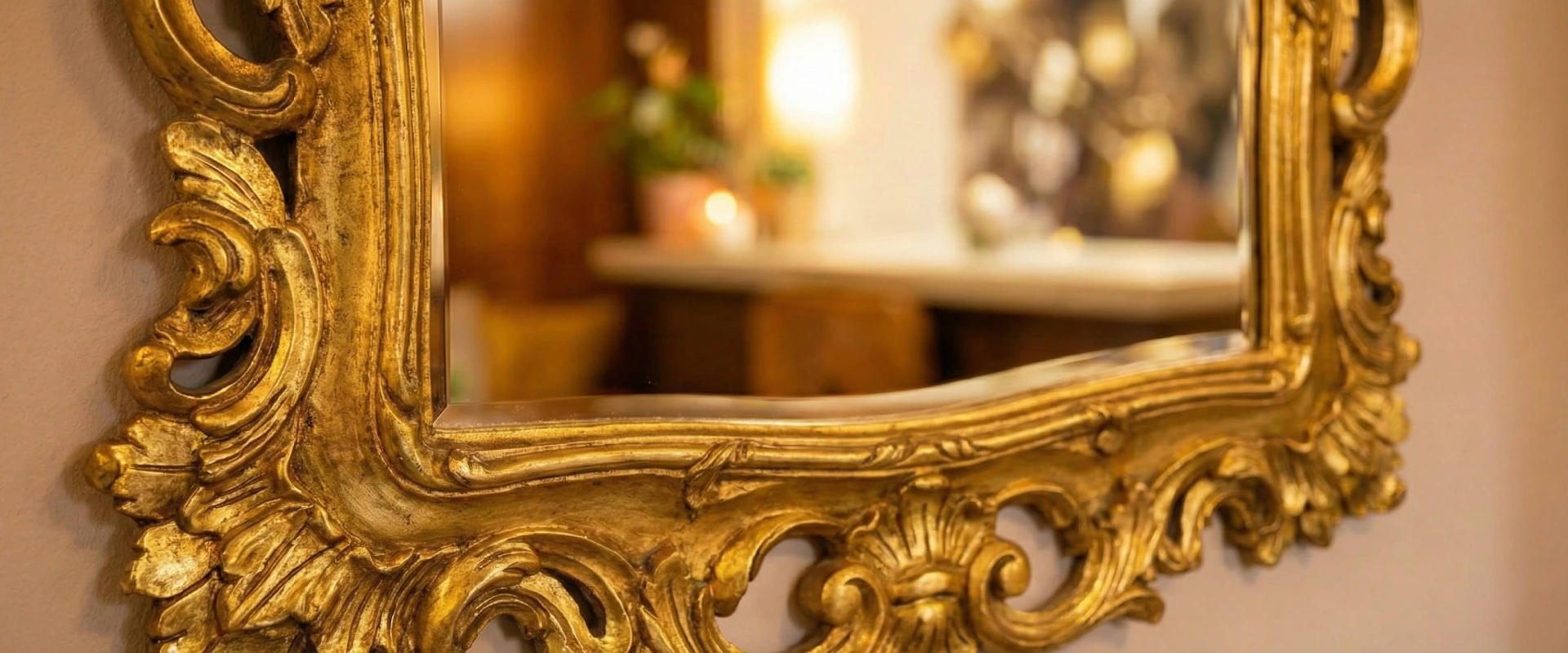 Espejo con marco dorado y decorativo en entorno c&aacute;lido de interior.