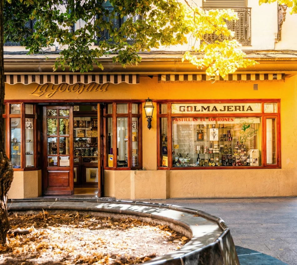Tienda antigua de golosinas con escaparate y fachada soleada.