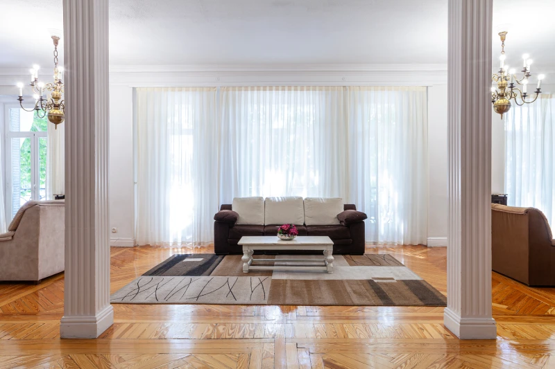 Sala elegante con sof&aacute;s, mesa de centro y candelabros.