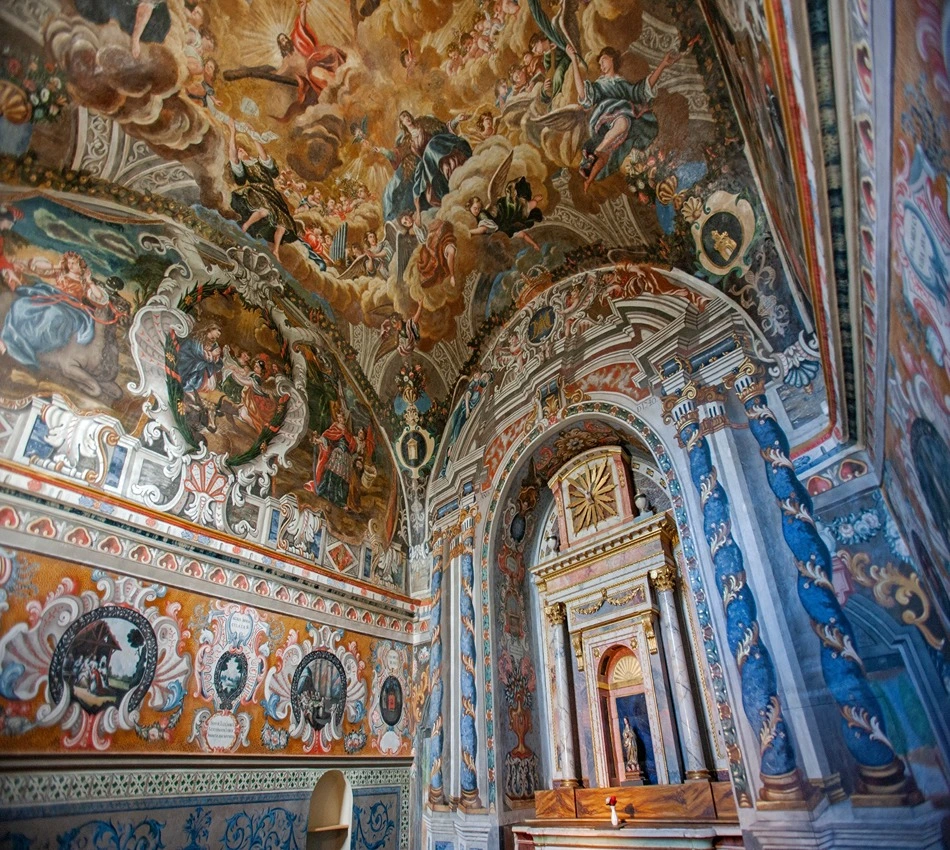 Techo de iglesia decorado con frescos detallados y coloridos.