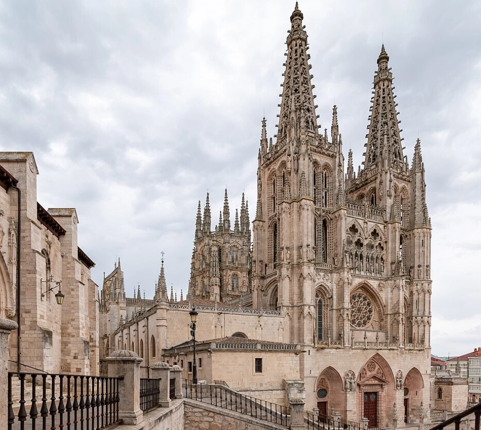 Catedral g&oacute;tica con altas torres y detalles intrincados bajo un cielo nublado.