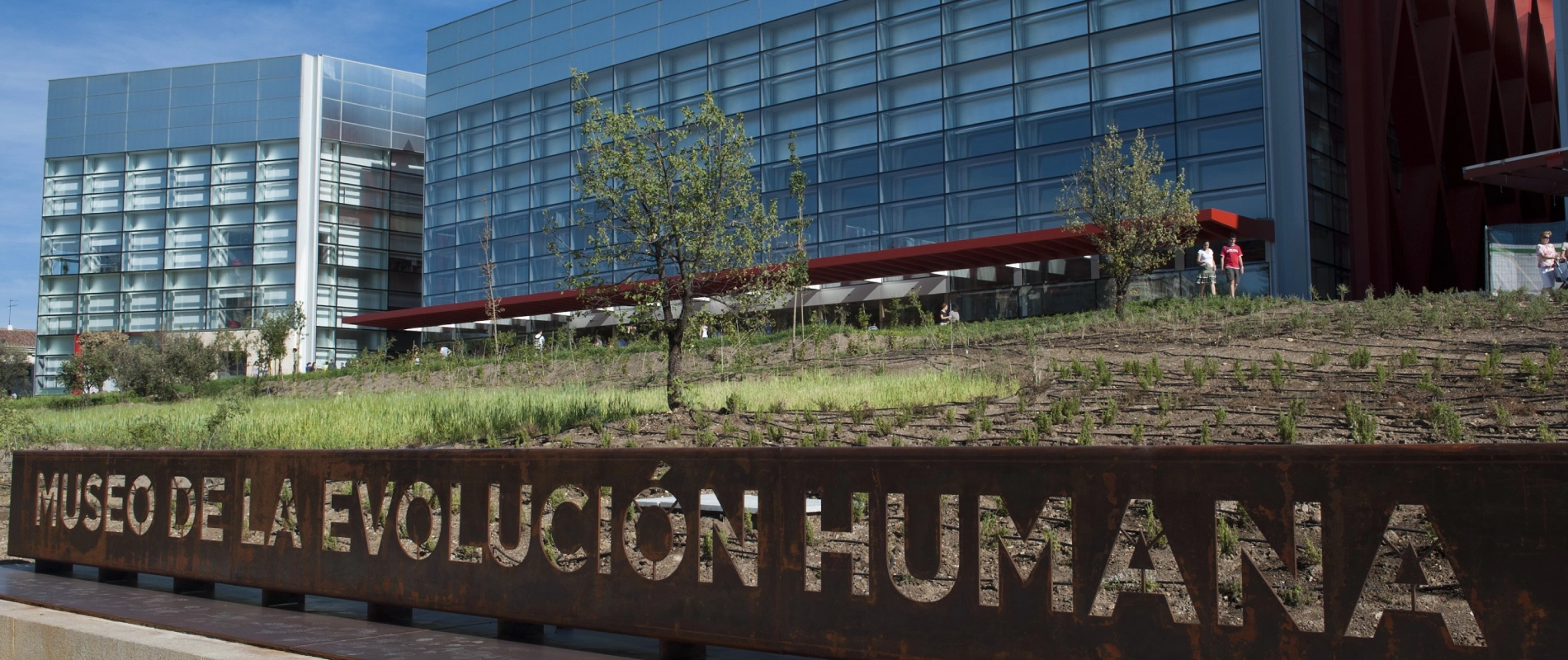 Museo de la Evoluci&oacute;n Humana con fachada moderna y jard&iacute;n en primer plano.