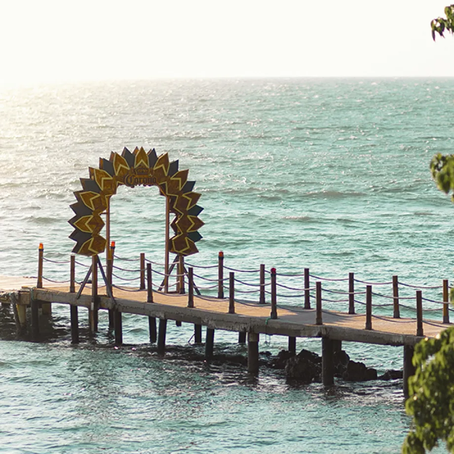 Un muelle con arco de madera sobre el mar en un día soleado.