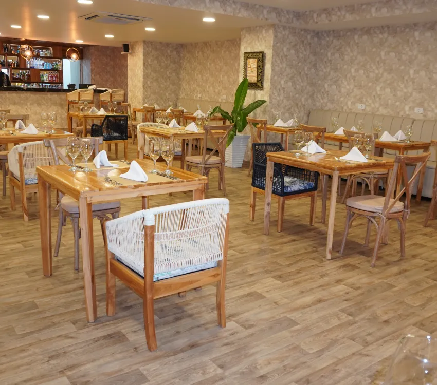 Restaurante acogedor con mesas de madera, decorado y bien iluminado.